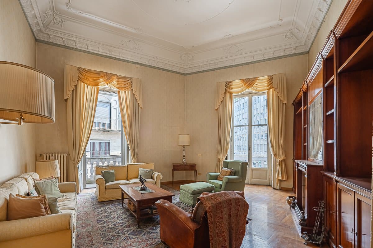 Il salone d'epoca con soffitti decorati e grandi finestre